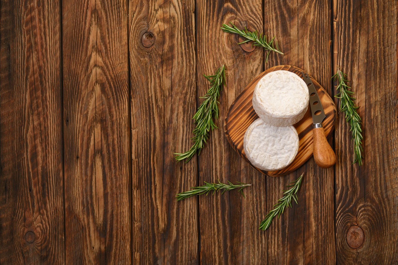 Brie cheese or camembert on woden board with knife for soft cheese