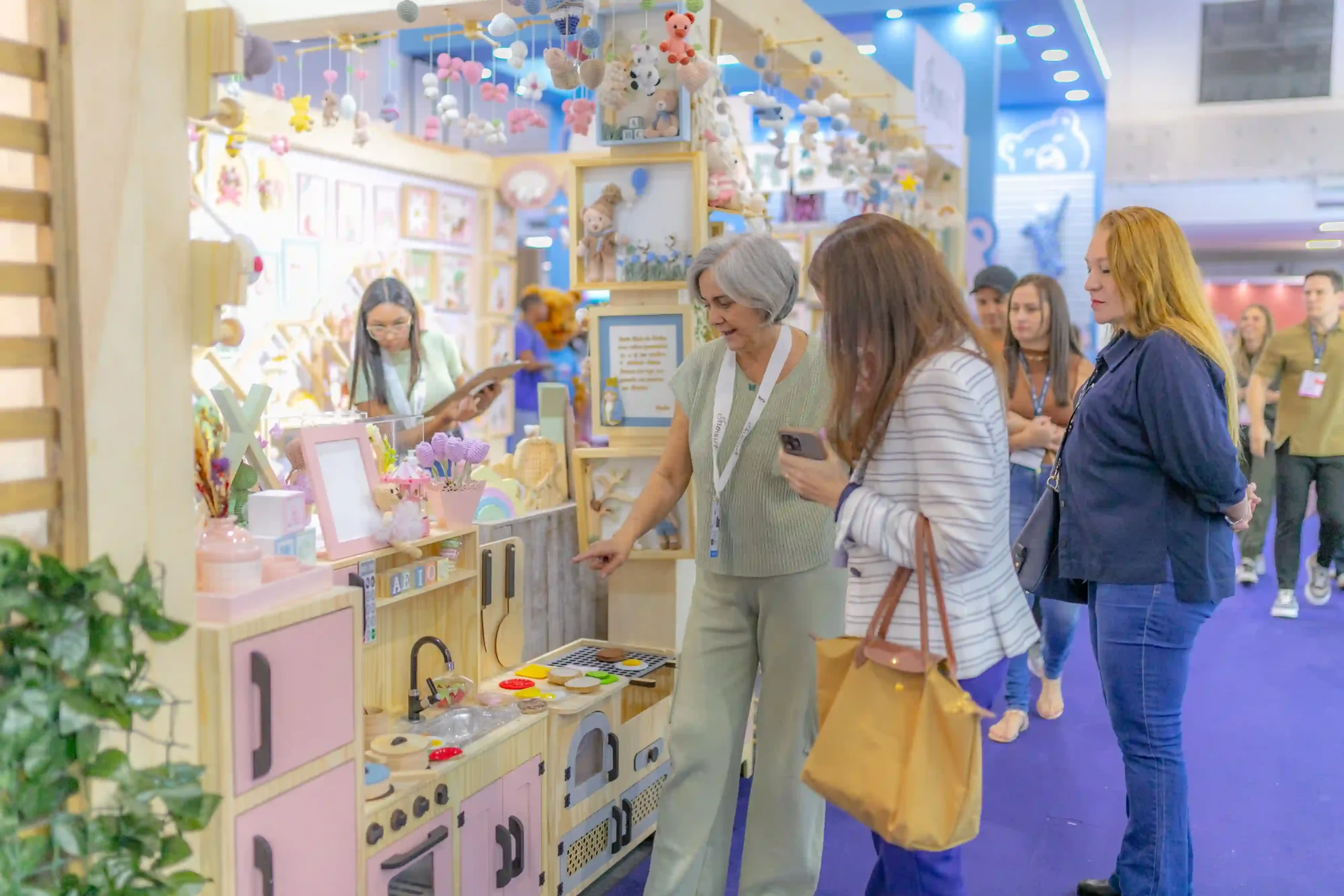 Crowded exhibition hall with vendor booths and attendee traffic
